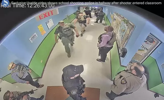 FILE - In this photo from surveillance video provided by the Uvalde Consolidated Independent School District via the Austin American-Statesman, authorities stage in a hallway as they respond to the shooting at Robb Elementary School in Uvalde, Texas, May 24, 2022. The former Uvalde schools police chief and another former officer have been indicted over their role in the slow police response to the 2022 massacre in a Texas elementary school that left 19 children and two teachers dead, according to multiple reports Thursday, June 27, 2024. (Uvalde Consolidated Independent School District/Austin American-Statesman via AP, File)