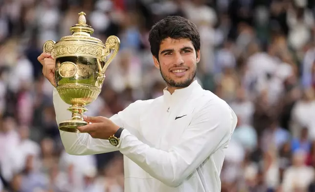 FILE - Spain's Carlos Alcaraz celebrates with the trophy after beating Serbia's Novak Djokovic to win the final of the men's singles on day fourteen of the Wimbledon tennis championships in London, Sunday, July 16, 2023. This year's Wimbledon tournament begins on Monday, July 1.(AP Photo/Kirsty Wigglesworth, File