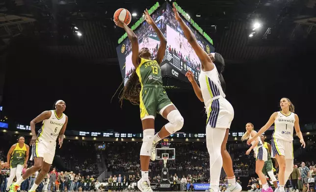 Seattle Storm's Ezi Magbegor (13) finds room in the lane to score over Dallas Wings' Teaira McCowan, center right, in the first quarter of a WNBA basketball game Saturday, June 29, 2024, in Seattle. (Dean Rutz/The Seattle Times via AP)