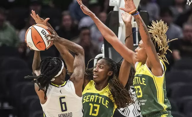 Seattle Storm's Ezi Magbegor (13) and Jordan Horston defend against Dallas Stars' Natasha Howard in the lane during the first quarter of a WNBA basketball game Saturday, June 29, 2024, in Seattle. (Dean Rutz/The Seattle Times via AP)