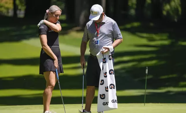 Charley Hull, of England, talks with her caddie on the fourth green during a practice round for the Womens PGA Championship golf tournament at Sahalee Country Club, Wednesday, June 19, 2024, in Sammamish, Wash. (AP Photo/Gerald Herbert)