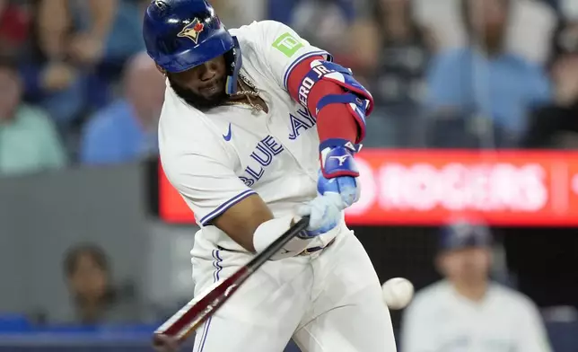 Toronto Blue Jays' Vladimir Guerrero Jr. (27) hits a two-run home run against the New York Yankees during the first inning of a baseball game in Toronto, Saturday, June 29, 2024. (Frank Gunn/The Canadian Press via AP)