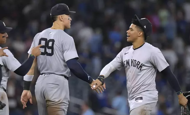 New York Yankees Aaron Judge (99) and Juan Soto celebrate the team's win over Toronto Blue Jays in a baseball game Friday, June 28, 2024, in Toronto. (Chris Young/The Canadian Press via AP)