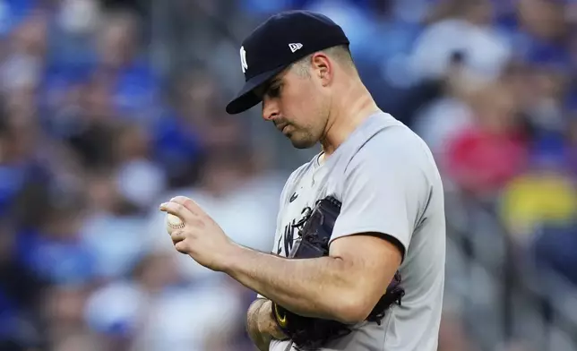 New York Yankees pitcher Carlos Rodon checks his grip during the second inning of a baseball game against the Toronto Blue Jays on Thursday, June 27, 2024, in Toronto. (Frank Gunn/The Canadian Press via AP)