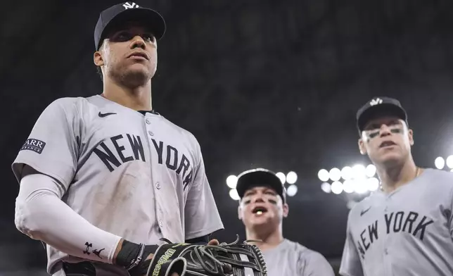 New York Yankees outfielders Juan Soto, Alex Verdugo and Aaron Judge, from left, look into the crowd as they head back to the dugout at the end of eighth inning of the team's baseball game against the Toronto Blue Jays on Friday, June 28, 2024, in Toronto. (Chris Young/The Canadian Press via AP)