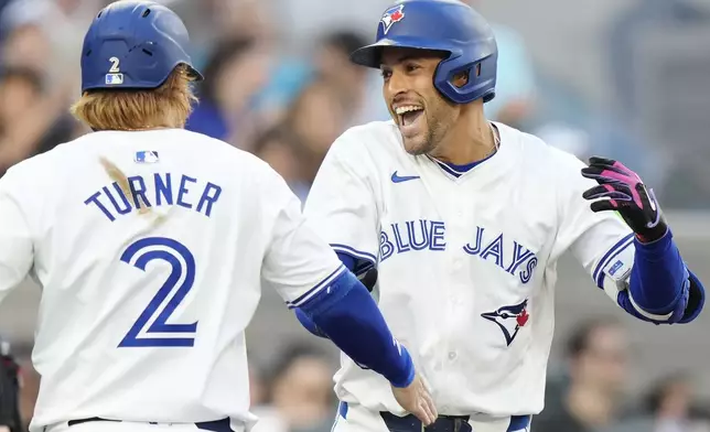 Toronto Blue Jays' George Springer, right, celebrates his three-run home run against the New York Yankees with Justin Turner (2) during the first inning of a baseball game in Toronto on Thursday, June 27, 2024. (Frank Gunn/The Canadian Press via AP)