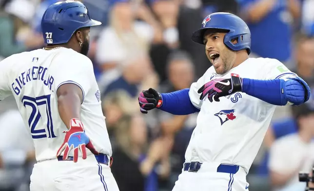 Toronto Blue Jays' George Springer, right, celebrates his three-run home run against the New York Yankees with Vladimir Guerrero Jr. (27) during the first inning of a baseball game in Toronto on Thursday, June 27, 2024. (Frank Gunn/The Canadian Press via AP)