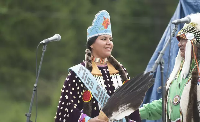 Miss Shoshnone-Bannock Queen Develynn Hall takes the stage during a naming ceremony for a white buffalo calf at the headquarters of the Buffalo Field Campaign in West Yellowstone, Mont., Wednesday, June 26, 2024. The reported birth of the calf in Yellowstone National Park fulfills a Lakota prophecy that portends better times. (AP Photo/Sam Wilson)