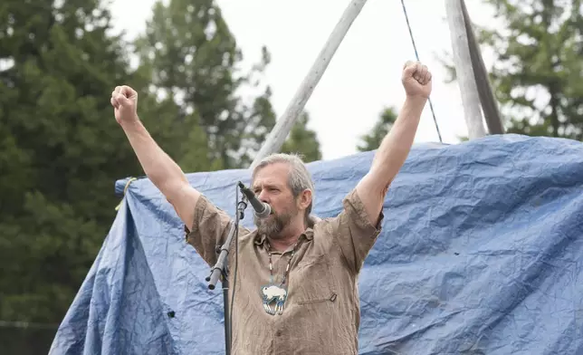 Mike Mease, co-founder of the Buffalo Field Campaign, raises his arms while concluding a speech during a naming ceremony for a recently born white buffalo calf in West Yellowstone, Mont., Wednesday, June 26, 2024. The reported birth of the calf in Yellowstone National Park fulfills a Lakota prophecy that portends better times. (AP Photo/Sam Wilson)