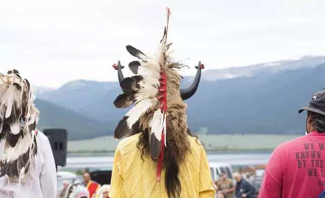 Ota Bluehorse wears a ceremonial headdress adorned with bison horns while attending a naming ceremony for a white buffalo calf, Wednesday, June 26, 2024, at the headquarters of the Buffalo Field Campaign in West Yellowstone, Mont. The reported birth of a white buffalo calf in Yellowstone National Park fulfills a Lakota prophecy that portends better times. (AP Photo/Sam Wilson)
