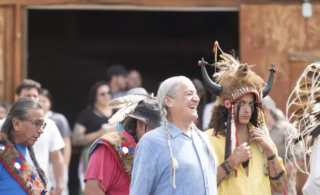 Dallas Gudgell, vice president of the Buffalo Field Campaign and member of the Assiniboine Souix, laughs during a naming ceremony for a white buffalo calf in West Yellowstone, Mont., Wednesday, June 26, 2024. The reported birth of a white buffalo calf in Yellowstone National Park fulfills a Lakota prophecy that portends better times. (AP Photo/Sam Wilson)