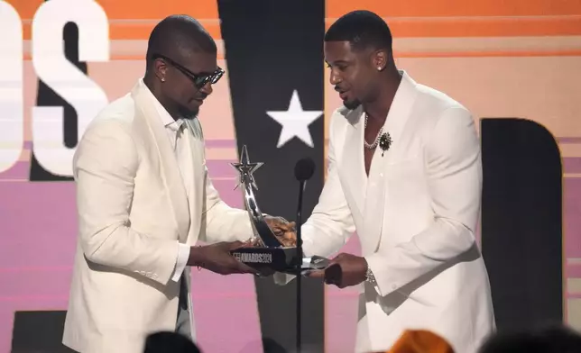 Devale Ellis, right, presents the award for best male R&amp;B/pop artist to Usher during the BET Awards on Sunday, June 30, 2024, at the Peacock Theater in Los Angeles. (AP Photo/Chris Pizzello)