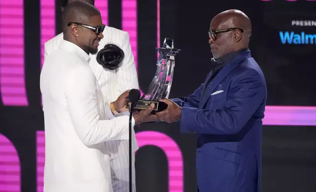 Usher, left, accepts the Lifetime Achievement Award from L.A. Reid during the BET Awards on Sunday, June 30, 2024, at the Peacock Theater in Los Angeles. (AP Photo/Chris Pizzello)