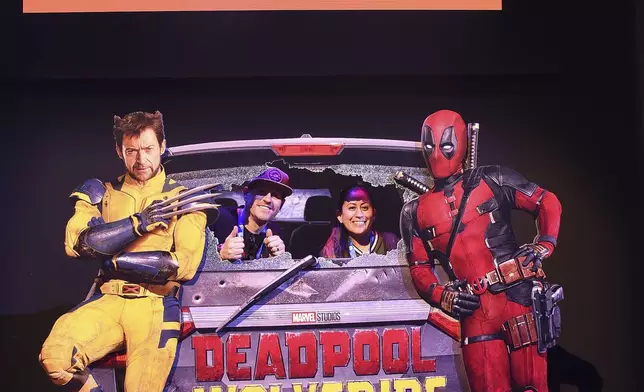 Fans pose for photos at a Marvel cardboard cutout at Comic-Con International on Thursday, July 25, 2024, in San Diego. (Photo by Richard Shotwell/Invision/AP)