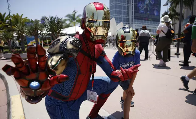 Brian Swanson, dressed as "Iron Spider," left, and Lincoln Swanson dressed as "Iron Man with Venom," of Nashville, Tenn. attend Comic-Con International on Friday, July 26, 2024, in San Diego. (Photo by Christy Radecic/Invision/AP)