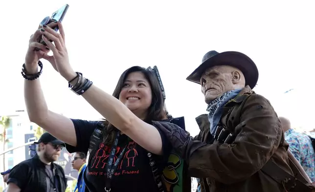 Charmaine Ong of San Diego, left, poses with Andrea J. Seale of Burbank, Calif., dressed as The Ghoul from the television series "Fallout" before preview night for Comic-Con International, Wednesday, July 24, 2024, in San Diego. (AP Photo/Chris Pizzello)