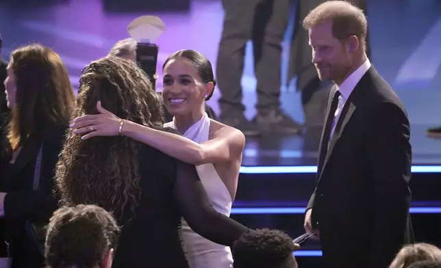 Meghan Markle, center and Prince Harry, right, arrive at the ESPY awards on Thursday, July 11, 2024, at the Dolby Theatre in Los Angeles. (AP Photo/Mark J. Terrill)