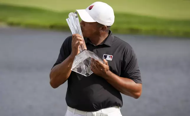 Jhonattan Vegas kisses the trophy after winning the 3M Open golf tournament at the Tournament Players Club, Sunday, July 28, 2024, in Blaine, Minn. (AP Photo/Charlie Neibergall)