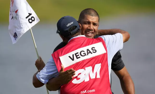 Jhonattan Vegas, right, celebrates with his caddie Ruben Yourio after winning the 3M Open golf tournament at the Tournament Players Club, Sunday, July 28, 2024, in Blaine, Minn. (AP Photo/Charlie Neibergall)