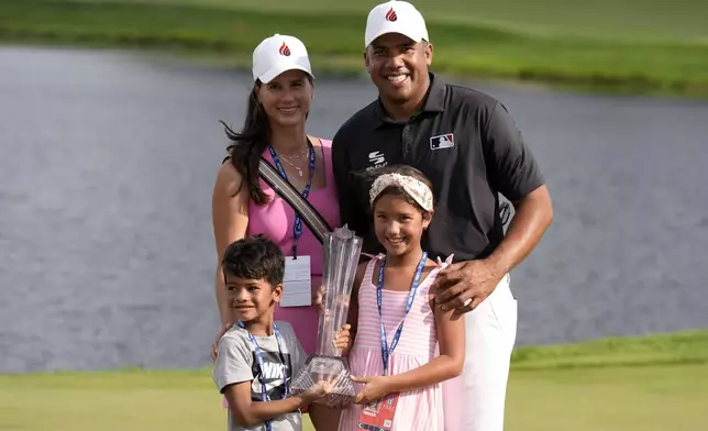 Jhonattan Vegas poses for a photo with his wife Hildegard, left, son Louis and daughter Sharlene after winning the 3M Open golf tournament at the Tournament Players Club, Sunday, July 28, 2024, in Blaine, Minn. (AP Photo/Charlie Neibergall)