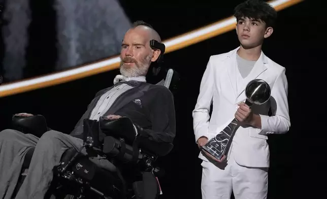 Steve Gleason, left, recieves the Arthur Ashe Award for Courage, held by his son Rivers, right, at the ESPY awards on Thursday, July 11, 2024, at the Dolby Theatre in Los Angeles. (AP Photo/Mark J. Terrill)