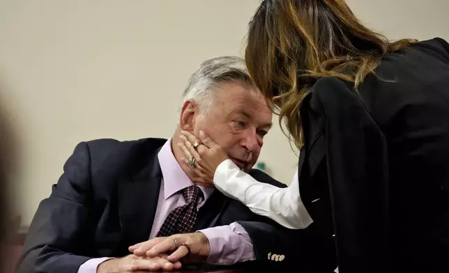 Actor Alec Baldwin interacts with his wife Hilaria Baldwin during his hearing in Santa Fe County District Court, Wednesday, July 10, 2024, in Santa Fe, N.M. Baldwin is facing a single charge of involuntary manslaughter in the death of a cinematographer. (AP Photo/Ross D. Franklin, Pool)