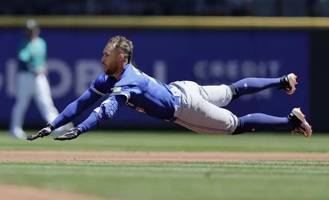 Toronto Blue Jays' George Springer dives into second for a double against the Seattle Mariners during the first inning in a baseball game, Saturday, July 6, 2024, in Seattle. (AP Photo/John Froschauer)