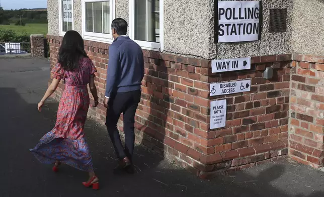 Britain's Prime Minister Rishi Sunak and his wife Akshata Murty walk from a polling station after voting near Richmond, North Yorkshire, England, Thursday, July 4, 2024. Britain goes to the polls Thursday after Prime Minister Rishi Sunak called a general election. (AP Photo/Scott Heppell )