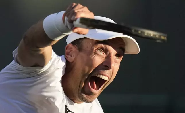 Roberto Bautista Agut of Spain serves to Tommy Paul of the United States during their fourth round match at the Wimbledon tennis championships in London, Sunday, July 7, 2024. (AP Photo/Mosa'ab Elshamy)