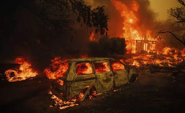 A property is engulfed in flames as the Thompson Fire burns, Tuesday, July 2, 2024, in Oroville, Calif. (AP Photo/Ethan Swope)