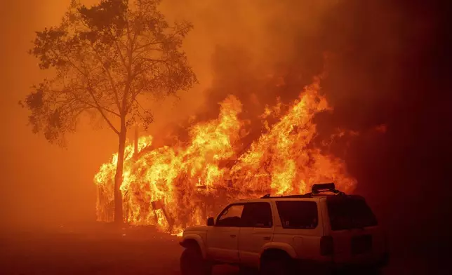 Flames consume a building as the Park Fire tears through the Cohasset community in Butte County, Calif., on Thursday, July 25, 2024. (AP Photo/Noah Berger)