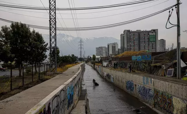 A homeless Chilean man who gave his name as Jose collects items, such as metal, from the El Zanjón de la Aguada water canal, in hopes of reselling it in Santiago, Chile, Wednesday, May 15, 2024. Over the last four years, the rate of homelessness in one of South America's richest economies has jumped more than 30%. (AP Photo/Esteban Felix)