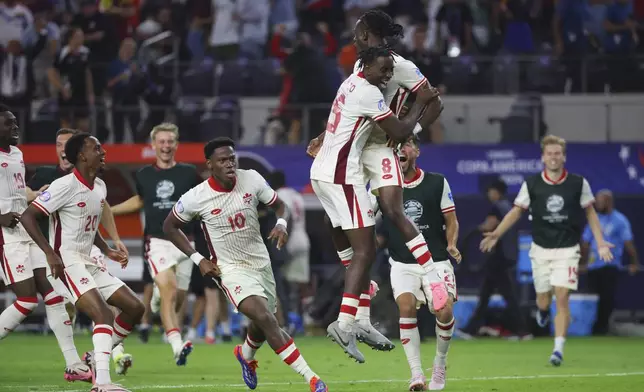 Canada midfielder Ismael Kone (8) celebrates with teammates after making the winning penalty kick against Venezuela a Copa America quarterfinal soccer match in Arlington, Texas, Friday, July 5, 2024. (AP Photo/Richard Rodriguez)