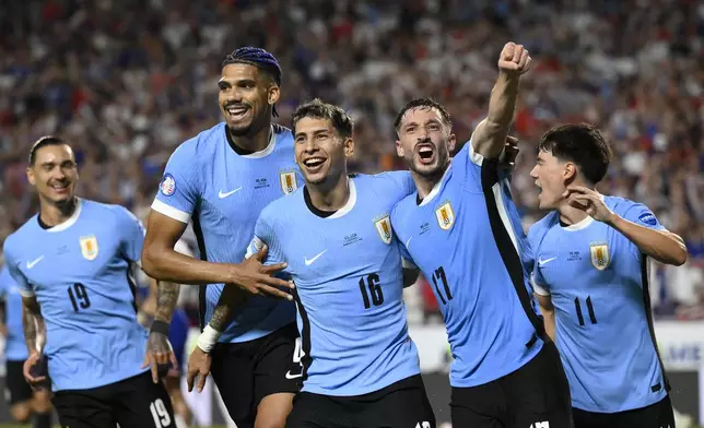 Uruguay's Mathias Olivera (16), celebrates with teammates after scoring his side's opening goal against United States during a Copa America Group C soccer match in Kansas City, Mo., Monday, July 1, 2024. (AP Photo/Reed Hoffman)