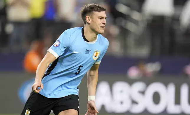 Uruguay's Manuel Ugarte celebrates scoring the winning goal in a penalty shootout against Brazil in a Copa America quarterfinal soccer match in Las Vegas, Saturday, July 6, 2024. (AP Photo/Julio Cortez)