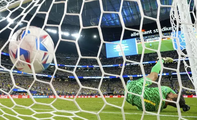 Brazil's goalkeeper Alisson fails to stop a shot from Uruguay's Giorgian De Arrascaeta in a penalty shootout during a Copa America quarterfinal soccer match in Las Vegas, Saturday, July 6, 2024. (AP Photo/Julio Cortez)