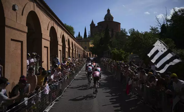 Riders climb the Col de San Luca climb along the Portico di San Luca, left, during the second stage of the Tour de France cycling race over 199.2 kilometers (123.8 miles) with start in Cesenatico and finish in Bologna, Italy, Sunday, June 30, 2024. (AP Photo/Daniel Cole)