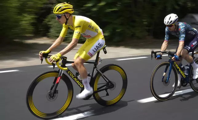 Slovenia's Tadej Pogacar, wearing the overall leader's yellow jersey, is followed by Slovenia's Jan Tratnik during the third stage of the Tour de France cycling race over 230.8 kilometers (143.4 miles) with start in Piacenza and finish in Turin, Italy, Monday, July 1, 2024. (AP Photo/Jerome Delay)