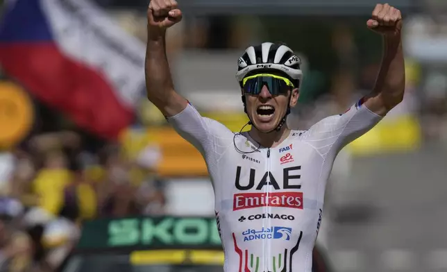 Slovenia's Tadej Pogacar celebrates as he crosses the finish line to win the fourth stage of the Tour de France cycling race over 139.6 kilometers (86.7 miles) with start in Pinerolo, Italy and finish in Valloire, France, Tuesday, July 2, 2024. (AP Photo/Jerome Delay)