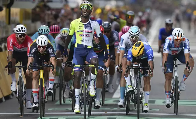 Eritrea's Biniam Girmay celebrates as he crosses the finish line ahead of Netherlands' Dylan Groenewegen, left, Belgium's Arnaud de Lie, second left, Colombia's Fernado Gavira, second right, ans Netherlands' Fabio Jakobsen, right, to win the third stage of the Tour de France cycling race over 230.8 kilometers (143.4 miles) with start in Piacenza and finish in Turin, Italy, Monday, July 1, 2024. (AP Photo/Daniel Cole)