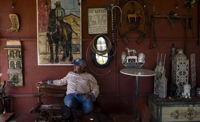 Date palm ranch owner Carlos Ulloa sits for a photo at Rancho El Refugio in Twentynine Palms, Calif., Tuesday, June 11, 2024. Ulloa's vision was to create a place where he could keep his horses and have a working ranch with sheep and peacocks while hosting events where families could have ample space to invite their relatives to a celebration without going broke. (AP Photo/Jae C. Hong)