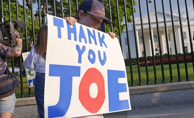 Hugh Kieve, 10, of Washington, holds a sign outside the White House in Washington, Sunday, July 21, 2024, as he and his family come out to show support for President Joe Biden. Biden dropped out of the 2024 race for the White House on Sunday, ending his bid for reelection following a disastrous debate with Donald Trump that raised doubts about his fitness for office just four months before the election. (AP Photo/Susan Walsh)