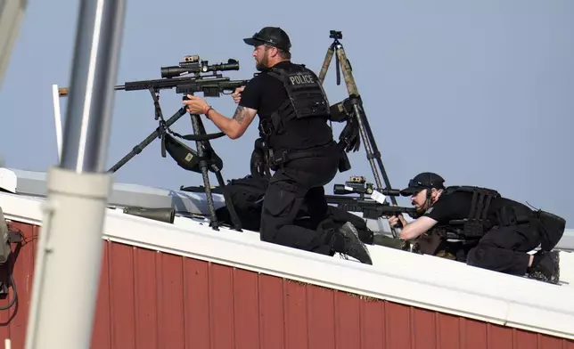 Police snipers return fire after shots were fired while Republican presidential candidate former President Donald Trump was speaking at a campaign event in Butler, Pa., on Saturday, July 13, 2024. (AP Photo/Gene J. Puskar)