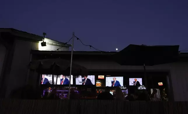 Supporters watch Republican presidential candidate former President Donald Trump speak at the Republican National Convention on a television Thursday, July 18, 2024, in Seal Beach, Calif. (AP Photo/Ashley Landis)