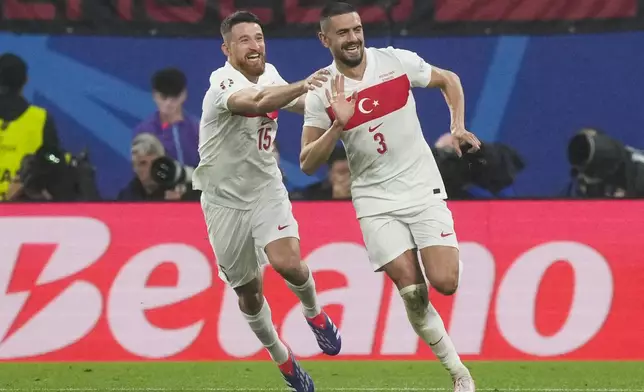 Turkey's Merih Demiral, right, celebrates with Salih Ozcan after scoring his side's second goal during a round of sixteen match between Austria and Turkey at the Euro 2024 soccer tournament in Leipzig, Germany, Tuesday, July 2, 2024. (AP Photo/Martin Meissner)