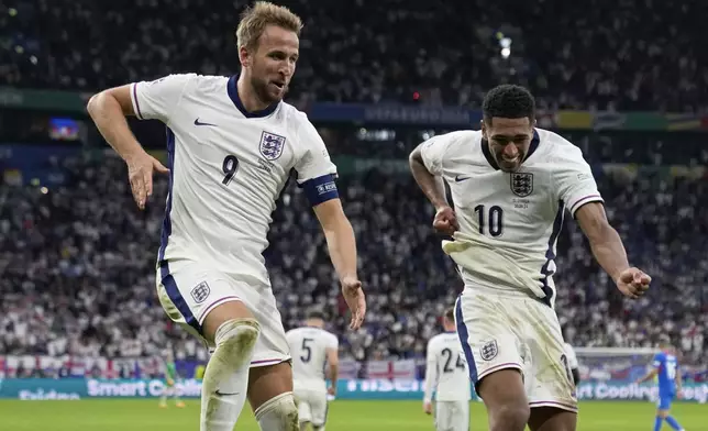 England's Harry Kane, left, celebrates with Jude Bellingham after scoring his side's second goal during a round of sixteen match between England and Slovakia at the Euro 2024 soccer tournament in Gelsenkirchen, Germany, Sunday, June 30, 2024. (AP Photo/Thanassis Stavrakis)