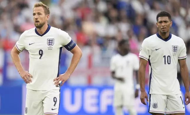 England's Harry Kane, left, and Jude Bellingham stand on the pitch during a round of sixteen match between England and Slovakia at the Euro 2024 soccer tournament in Gelsenkirchen, Germany, Sunday, June 30, 2024. (AP Photo/Matthias Schrader)