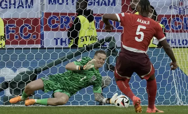 England's goalkeeper Jordan Pickford makes a save from Switzerland's Manuel Akanji during penalty shootout of the quarterfinal match between England and Switzerland at the Euro 2024 soccer tournament in Duesseldorf, Germany, Saturday, July 6, 2024. (AP Photo/Thanassis Stavrakis)