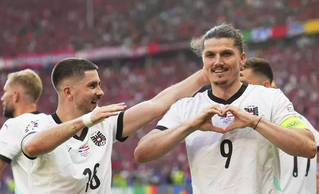 Austria's Marcel Sabitzer, right, celebrates after scoring his side's third goal during a Group D match between the Netherlands and Austria at the Euro 2024 soccer tournament in Berlin, Germany, Tuesday, June 25, 2024. (Michael Kappeler/dpa via AP)