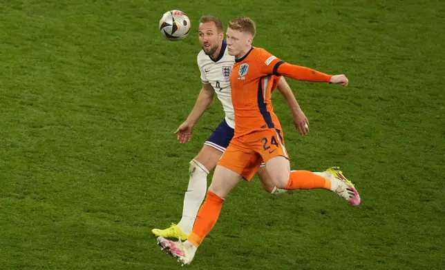 England's Harry Kane challenges for the ball with Jerdy Schouten of the Netherlands during a semifinal match between the Netherlands and England at the Euro 2024 soccer tournament in Dortmund, Germany, Wednesday, July 10, 2024. (AP Photo/Andreea Alexandru)